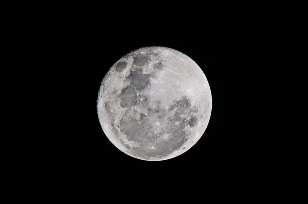 Detailed full moon captured against a black sky, showcasing lunar textures.
