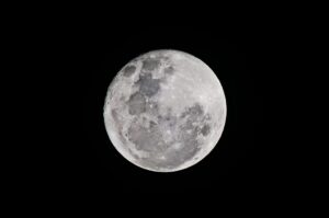 Detailed full moon captured against a black sky, showcasing lunar textures.